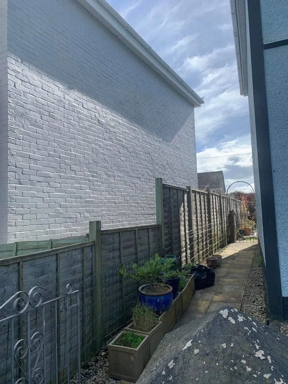 Freshly painted brick wall after preparation and masonry paint in Bude
